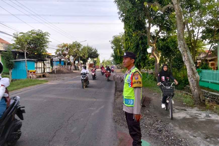 Sambut Pagi di SMPN 2 Pilangkenceng, Personel Polsek Pilangkenceng Pastikan Pelajar Menyeberang Aman